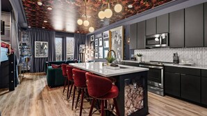 Une cuisine moderne dotée d’un îlot central, de tabourets de bar et d’un four à micro-ondes.