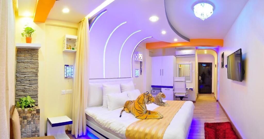 A modern bedroom with a bed, a tiger plush toy, and a leopard plush toy.