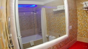 Ein Badezimmer mit Dusche, Toilette und einem gläsernen Bereich mit blauem Licht.