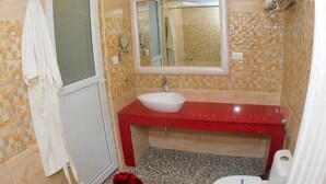Ein Badezimmer mit einem weißen Waschbecken, einer roten Arbeitsplatte und einer weißen Toilette.