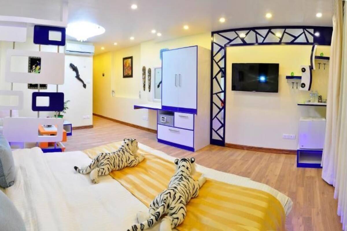 Una habitación de hotel moderna con una cama grande, un escritorio y un televisor.