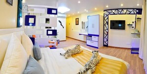 Una habitación de hotel moderna con una cama grande, un escritorio y un televisor.