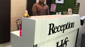 A reception desk with a sign reading "Reception" and "LHS". - Hotel Swarna Lata (Puri)