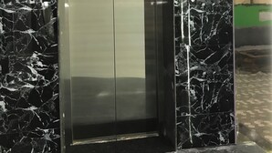 An elevator with a digital display showing the number 3, surrounded by black marble walls. - Hotel Swarna Lata (Puri)