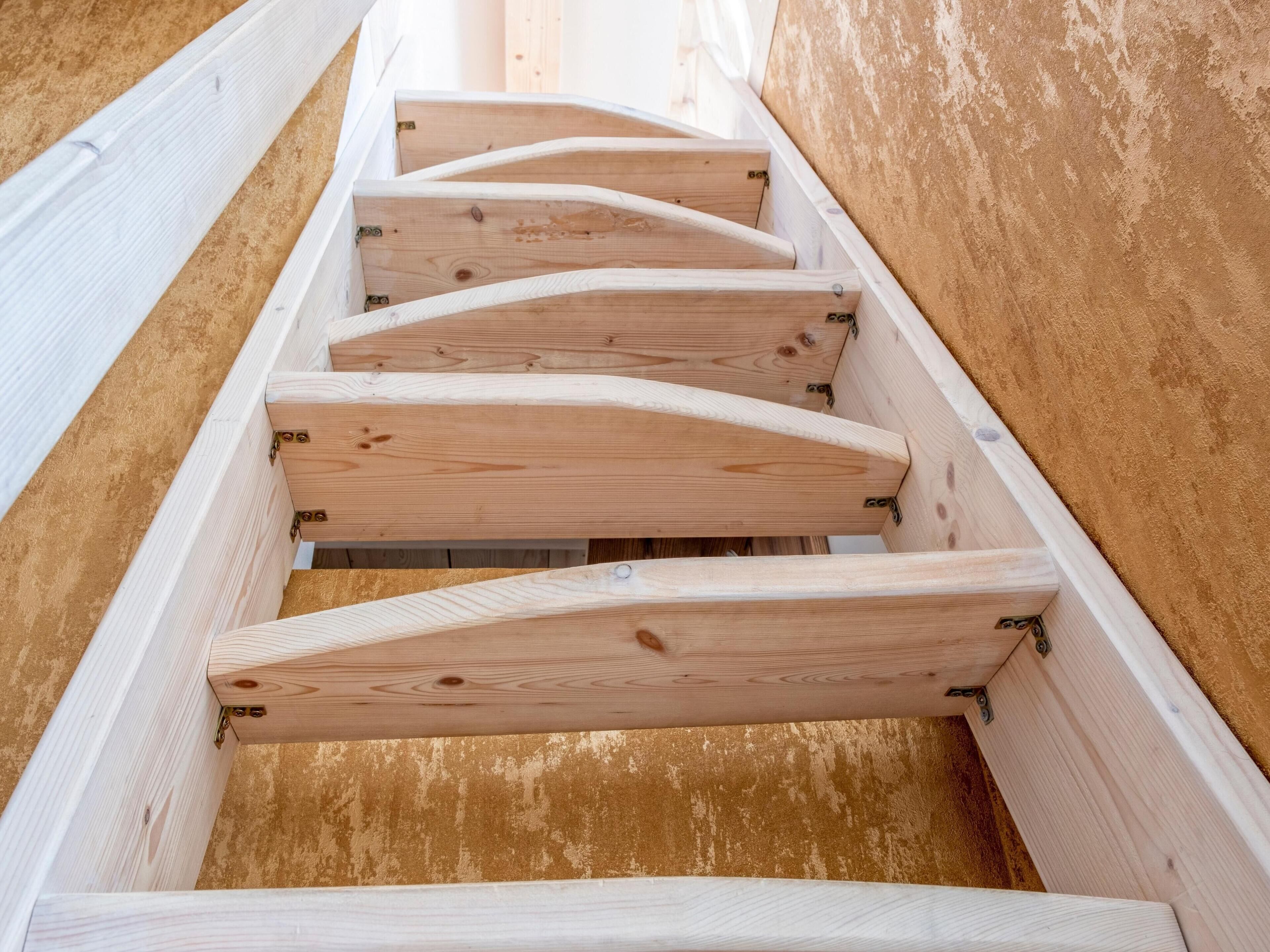 A wooden staircase with a handrail and steps.