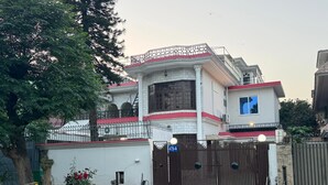 A gated residential property with a two-story building, a red-tiled roof, and a visible house number sign. - Serene Inn F10 (Islamabad)