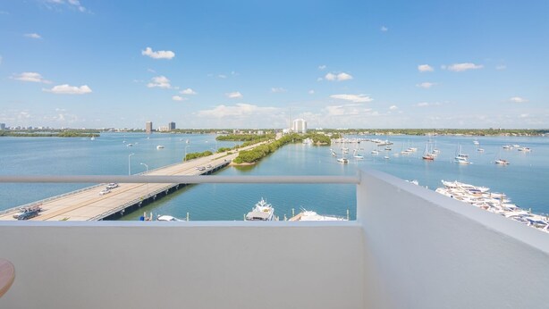 Ein Balkon mit Blick auf einen Jachthafen und eine Brücke.
