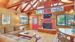 A wooden interior with a fireplace, a sofa, a dining table, and a television. - < 2 Blocks to Lake Tahoe: Family Home Near Skiing (Homewood)