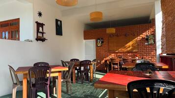 A dining area with brick walls, wooden tables, and chairs.