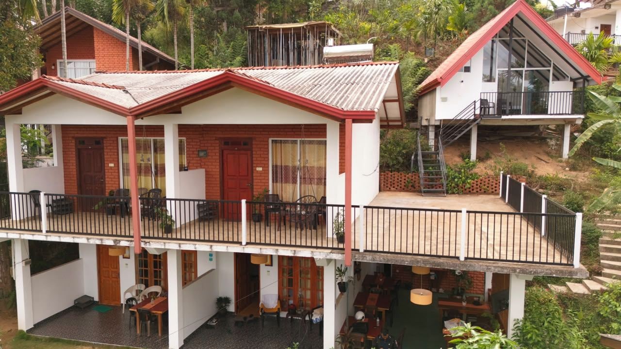 A two-story house with a balcony, a staircase, and a patio area.