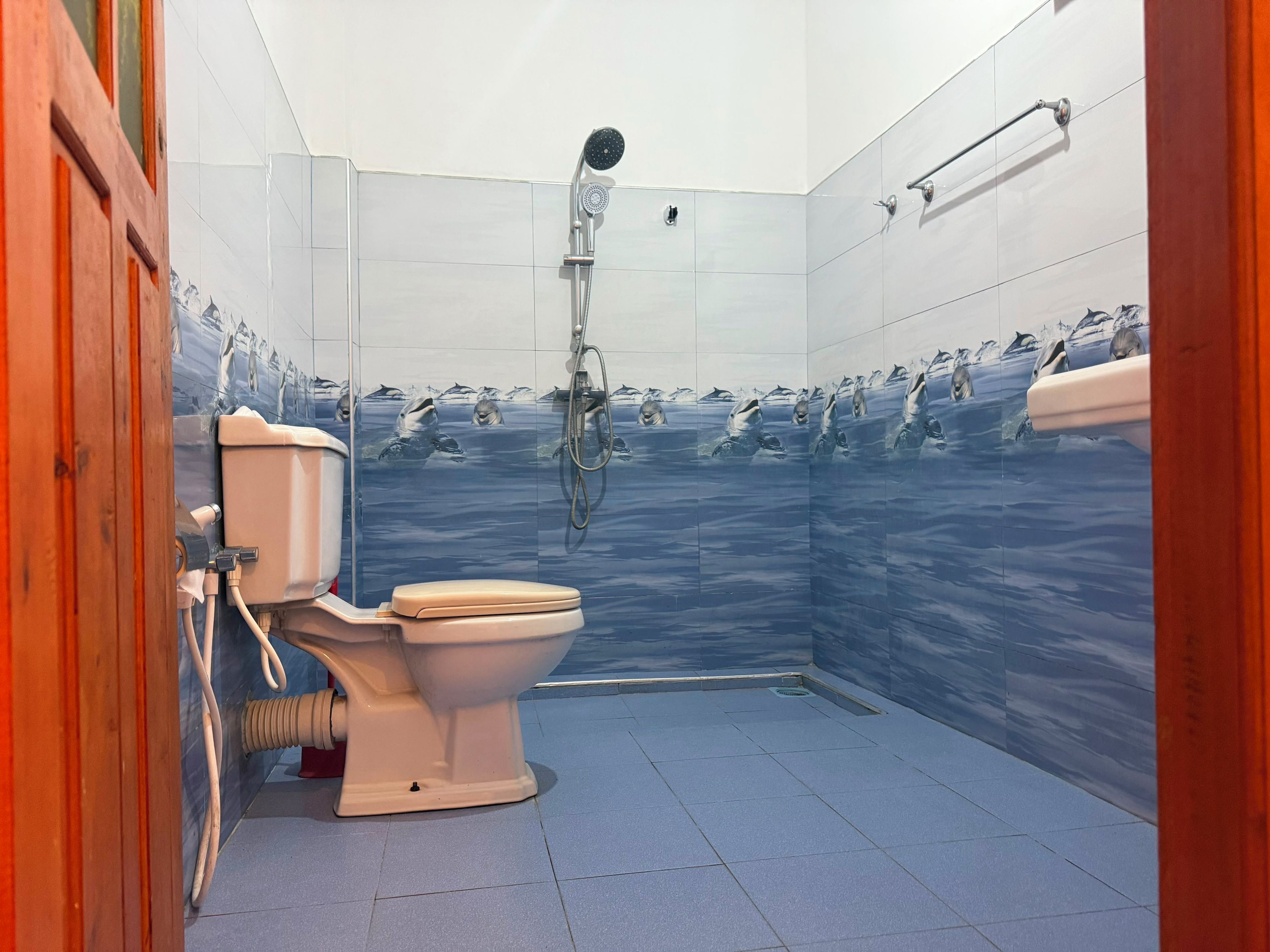 A bathroom with a toilet, shower, and tiled walls.