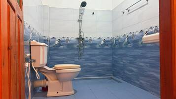A bathroom with a toilet, shower, and tiled walls.