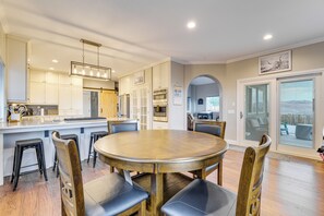 A spacious kitchen with a central island, a dining area with a round table, and a view through a glass door. - Mtn-View Haven w/ Hot Tub! 28 Mi to Mt Rose Ski (Sparks)