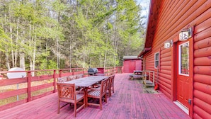 A wooden deck with a table and chairs, surrounded by a red fence, and a small shed in a forested area. - 15 Mi to Snowshoe Resort: Cabin w/ Deck & Fire Pit (Dunmore)