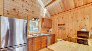 A wooden cabin kitchen with a stainless steel refrigerator, wooden cabinets, a sink, and a microwave. - 15 Mi to Snowshoe Resort: Cabin w/ Deck & Fire Pit (Dunmore)