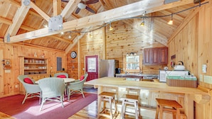 A wooden cabin interior with a dining area, kitchen, and bar. - 15 Mi to Snowshoe Resort: Cabin w/ Deck & Fire Pit (Dunmore)