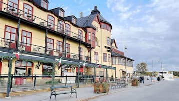 A waterfront hotel with multiple balconies, outdoor seating, and a bar.
