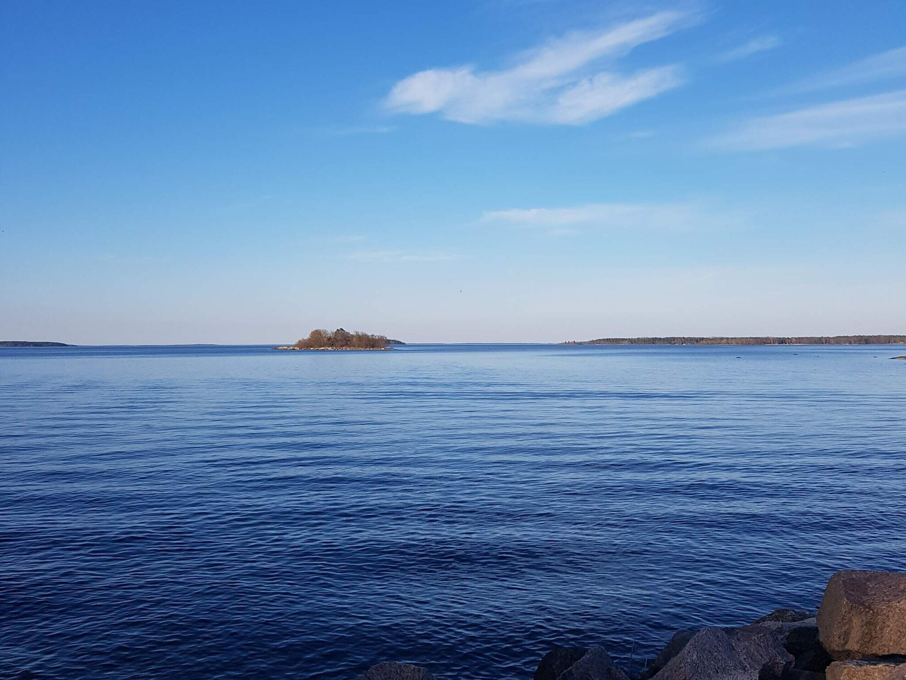 A calm body of water with a small island in the distance.