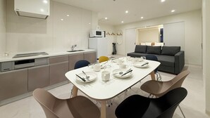Eine moderne Küche mit Essbereich, einer Sitzecke und einem Fernseher.
