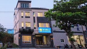 Un edificio de varios pisos con un letrero llamativo que dice "The Golden Sun B&B".