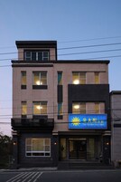 Un edificio de varios pisos con un cartel azul llamativo que dice "The Golden Sun B&B".