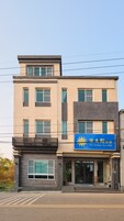 Un edificio de varios pisos con un letrero azul que dice "The Golden Sun B&B".