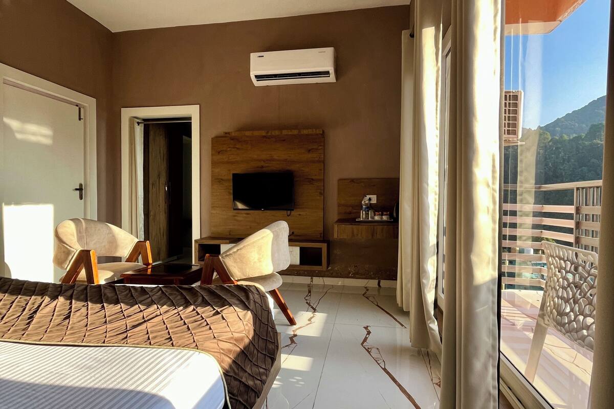 Un dormitorio moderno con una cama grande, un televisor y un balcón con vistas.