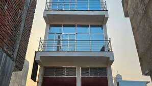 A multi-story building with a modern design, featuring a mix of glass and metal elements. - Shivam Guest House (Faizabad)