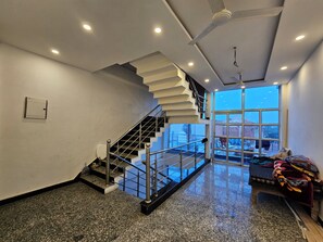 Un ambiente spazioso con una scala moderna, un'ampia finestra con vista e un pavimento pulito e lucido.