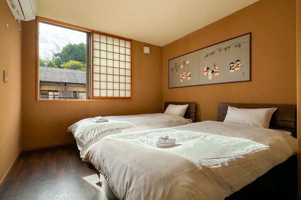 Bedroom with two single beds. A small refrigerator and microwave is provided.