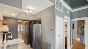 Una cocina moderna con encimera de acero inoxidable, un refrigerador grande y un horno empotrado.