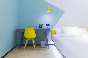 A bedroom with a bed, a desk with a chair, a kettle, and a small heater. - YIBAIJIUDIANNANWAITANDIAN (Shanghai)