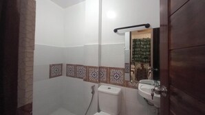 Un baño con inodoro, lavabo y zona de ducha.