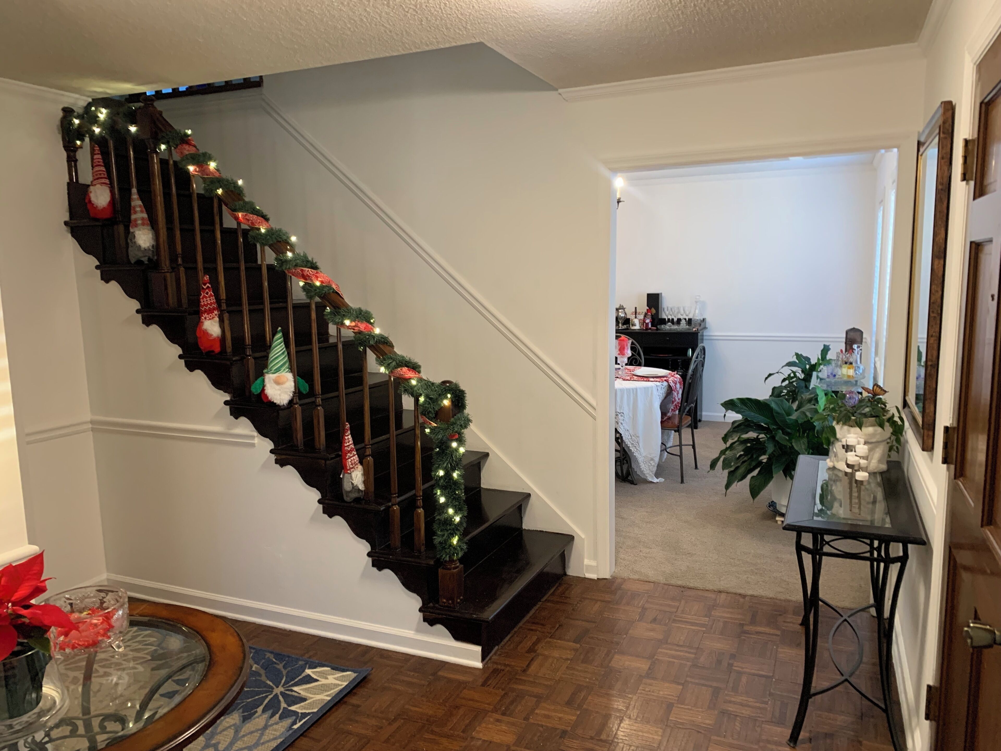 Un escalier décoré d’une guirlande lumineuse et d’ornements de fête.