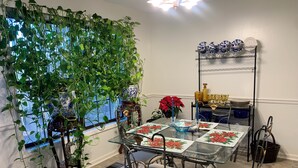Un comedor con mesa de vidrio, sillas de metal y una planta decorativa.