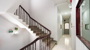 A staircase with wooden railings and a sign indicating an exit. - Phan Hotel (Ho Chi Minh City)