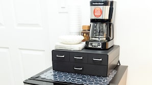 Een compacte Galanz koelkast met een koffiezetapparaat erop, een klein afdruiprek en een kruidenpot.