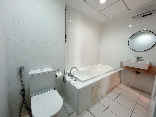 Une salle de bain moderne équipée de toilettes, d’une baignoire et d’un lavabo.
