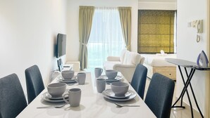 A modern hotel room with a dining area, a sofa, and a TV. - Solaris Dutamas by Manhattan Group  (Kuala Lumpur)