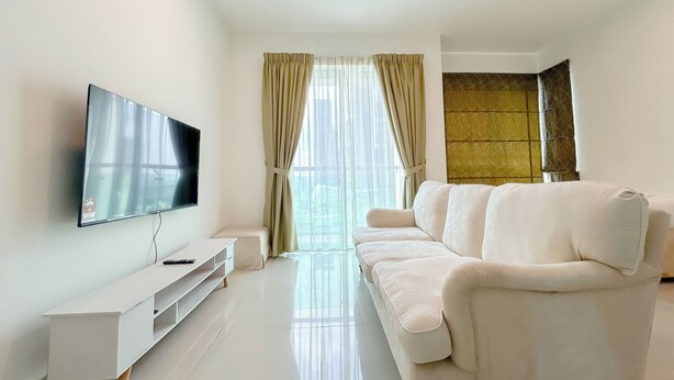 A modern living room with a flat-screen TV, a white sofa, and a glass coffee table. - Solaris Dutamas by Manhattan Group  (Kuala Lumpur)
