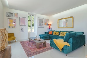 A living room with a teal sofa, a wooden coffee table, a yellow armchair, and a large mirror. - Salvibabette, a light and spacious holiday home in a gastronomic area (Vitrac)