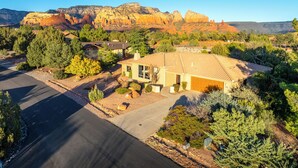 A residential area with houses, a paved driveway, and a mountain backdrop. - Carefree on the Rocks  - West Sedona location with a hot tub.  (Sedona)