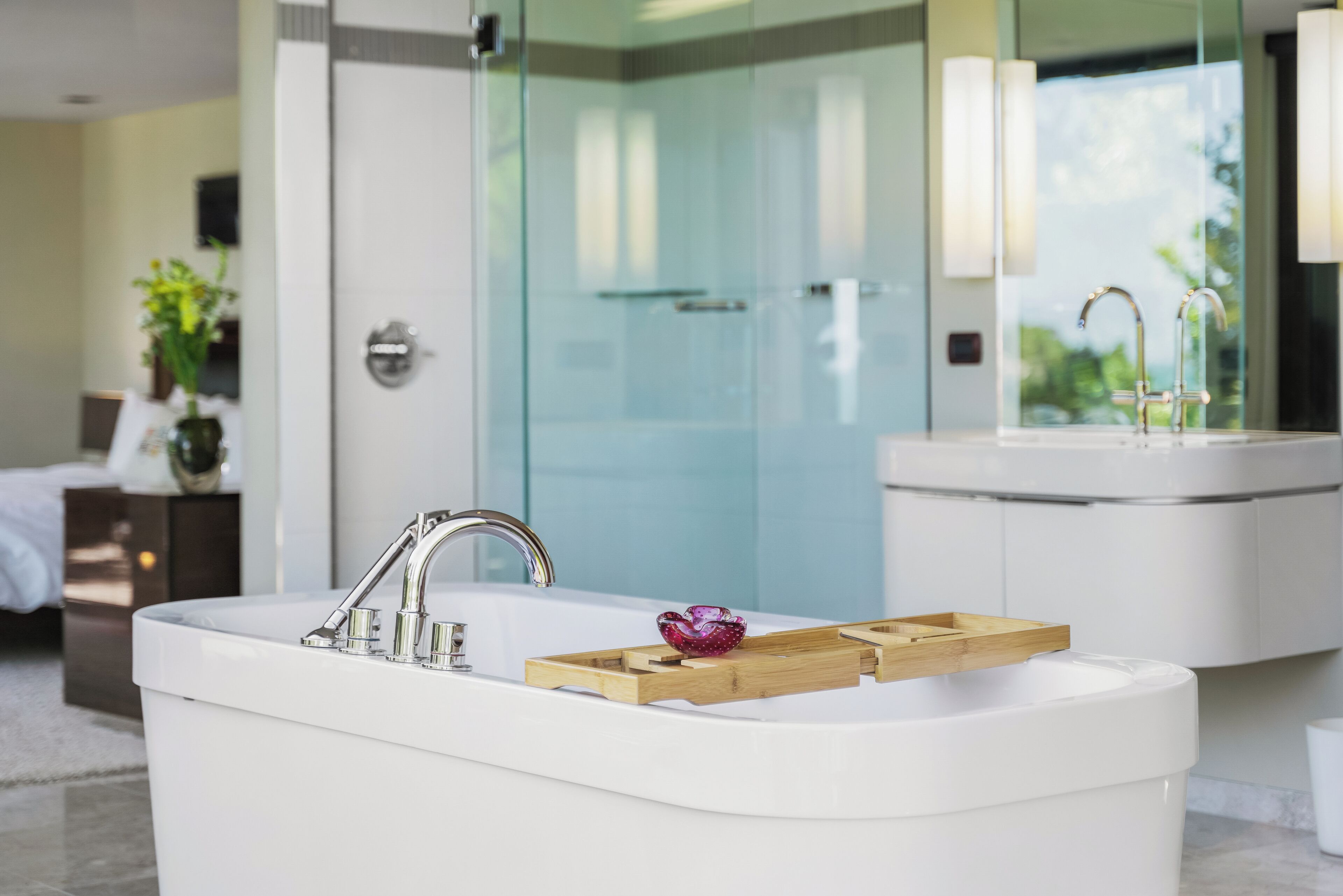 A modern bathroom with a freestanding bathtub, a glass shower enclosure, and a large mirror above the sink.