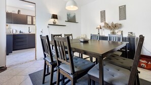 A dining area with a wooden table, chairs, and a pendant light.