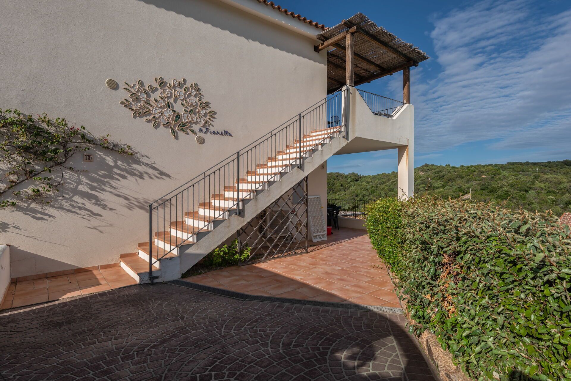Eine Treppe führt zu einem Balkon mit Blick auf eine üppige Landschaft.