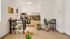 A compact kitchen with a dining area, a trash bin, and a potted plant. - Apartment 'Chill-out' with Wi-Fi (Heilbad Heiligenstadt)