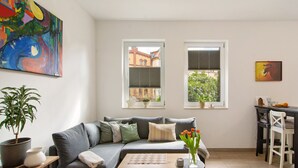 A living room with a grey sofa, a coffee table, a potted plant, and a chessboard. - Apartment 'Chill-out' with Wi-Fi (Heilbad Heiligenstadt)