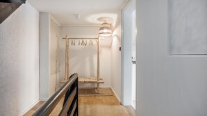 A hallway with a wooden bench, a hanging rack, and a ceiling light fixture. - Holiday Apartment 'Silvia' with Mountain View, Shared Garden, and Wi-Fi (Rosshaupten)
