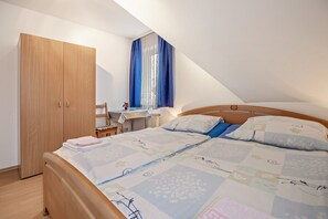 A bedroom with a bed, a wardrobe, a desk, and a window with curtains. - Apartment 'Hannover' with Wi-Fi (Hannover)