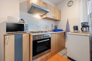 A compact kitchen with a microwave, stove, oven, and refrigerator. - Apartment 'Hannover' with Wi-Fi (Hannover)